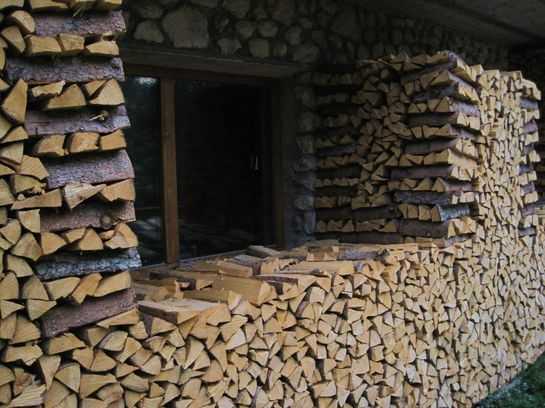 сложенные штабелем дрова возле дома